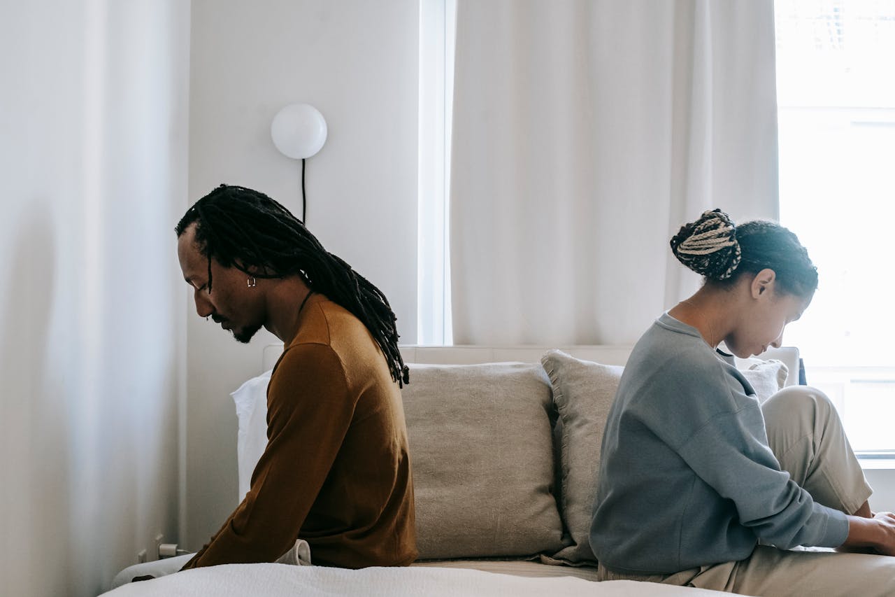 Couple sitting on the bed and talking about their intimacy issues.