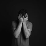 Man covering his face.