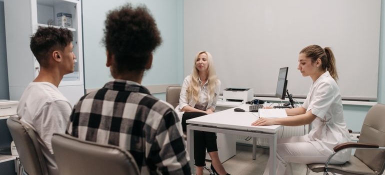 Patient and loved one speaking with healthcare professionals during a medical appointment.