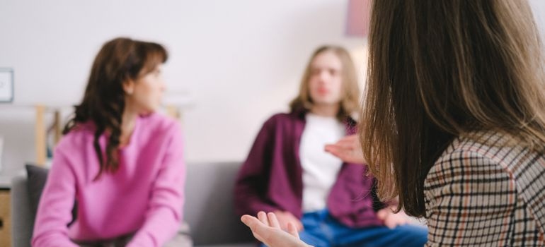 Adults talking during a structured group therapy session.