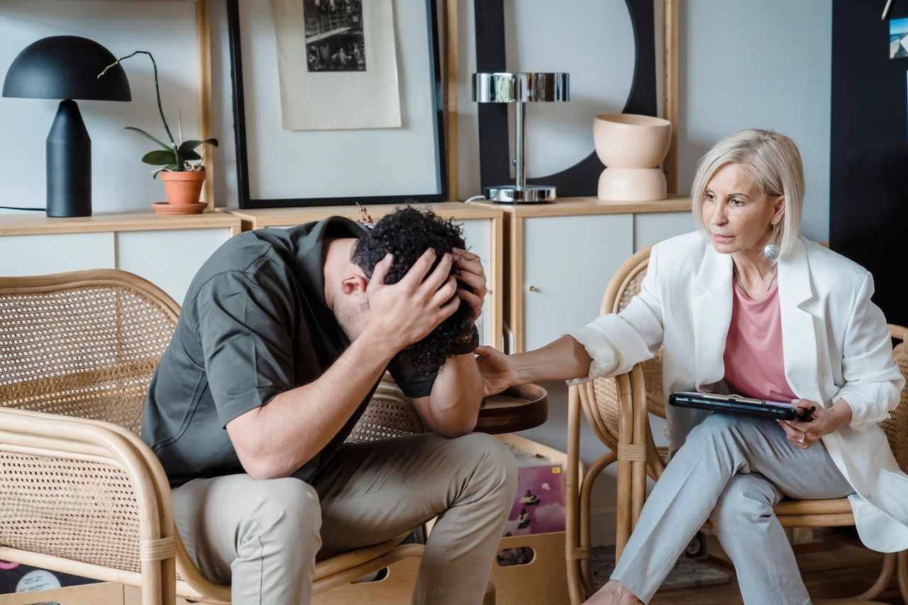 Therapist offering support to a man during a recovery counseling session.