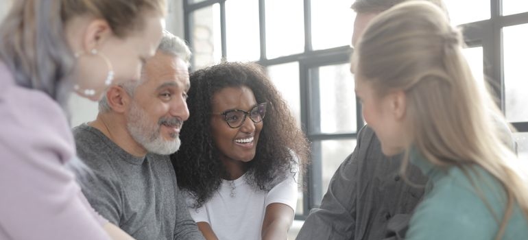 People in a suppor group smiling.
