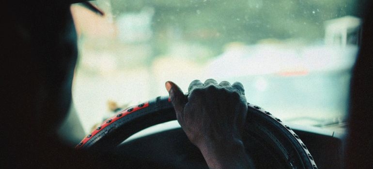Man holding a wheel while driving.