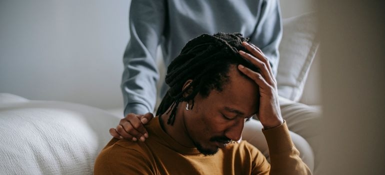 Woman supporting an upset man.