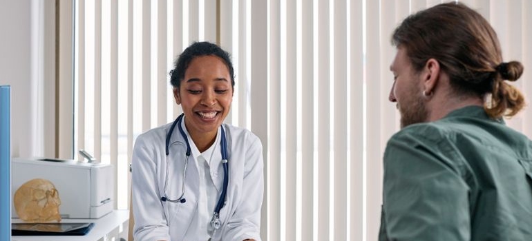 Male patient discussing alcohol-related health concerns with a doctor during a clinic visit.