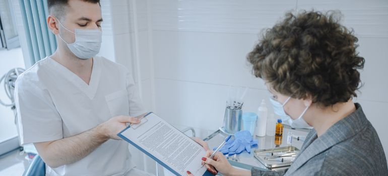 Doctor speaking with a patient and taking notes during an assessment of memory and cognitive concerns.