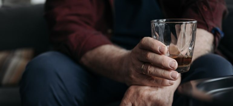 Man holding a glass of whiskey.