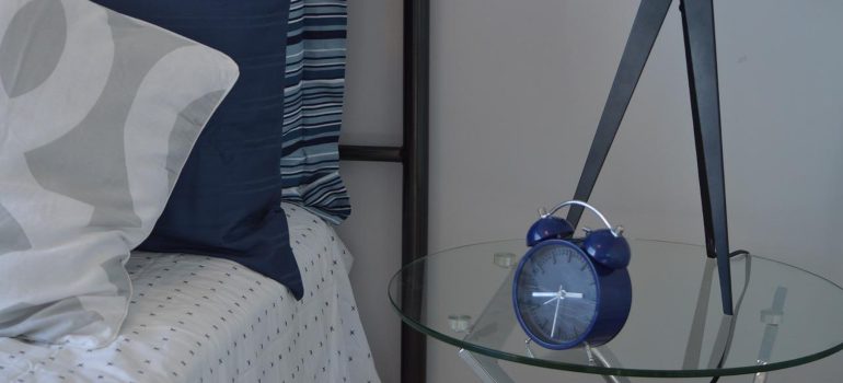 A blue alarm clock on an end table.