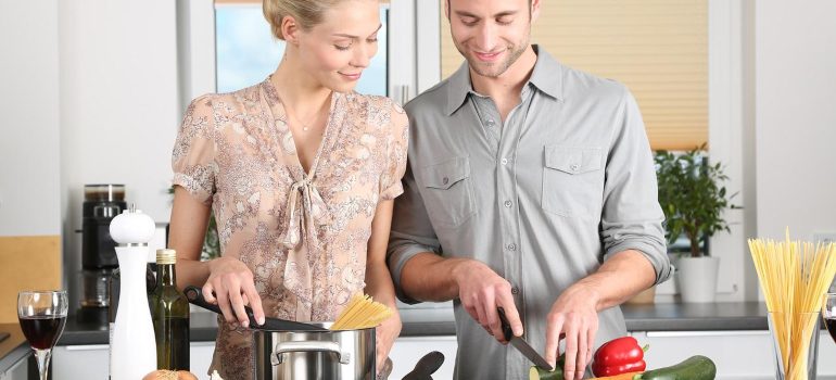 A man and a woman cooking in a kitchen after finding motivation for PA rehab.