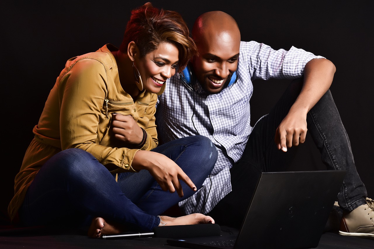 A man and a woman looking at a laptop.