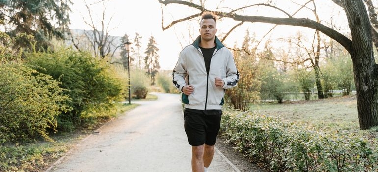 Man jogging through a park as part of a healthy routine.