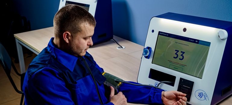 Man checking his blood pressure to check for changes you can expect after you stop drinking.