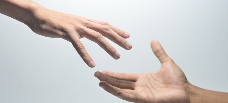 Hands reaching out to each other to offer support in rehab