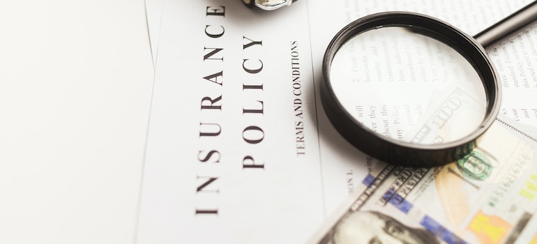 Insurance policy, money, and a magnifyng glass