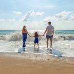 A family of three on the beach.