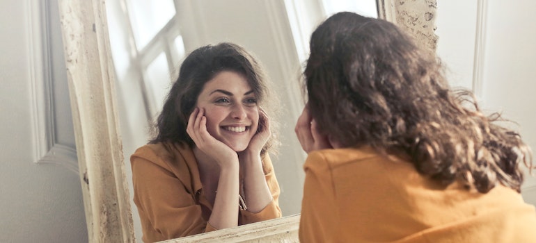 Woman admiring herself in the mirror after overcoming addiction.