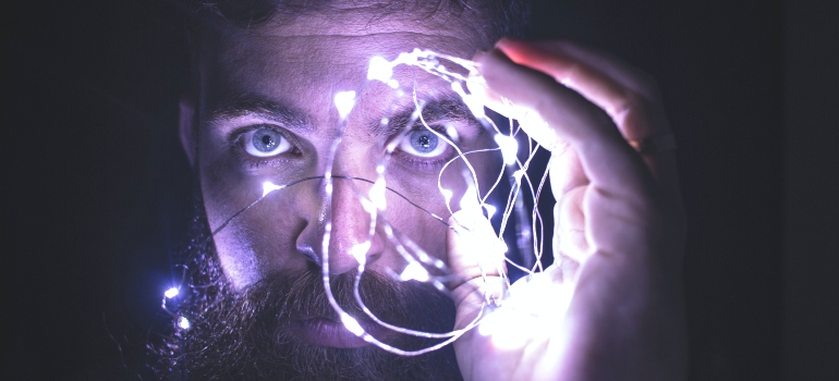 person holding stringed lights, representing brain connectivity