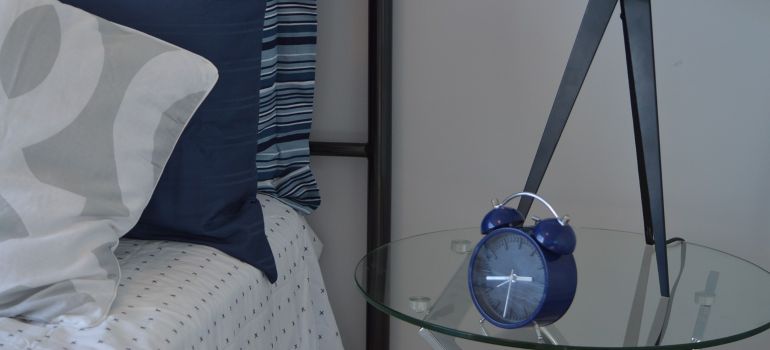 A blue alarm clock on an end table.