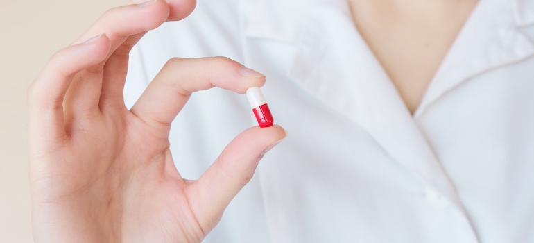 a woman holding a pill