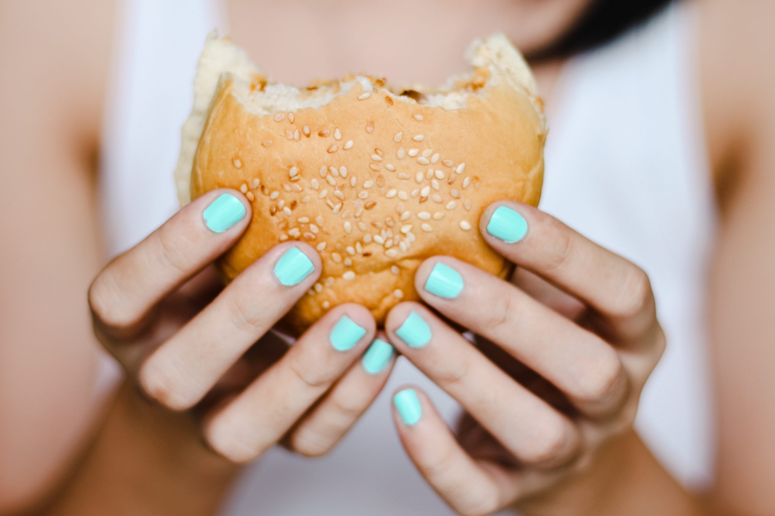 a person eating a burger representing eating disorders