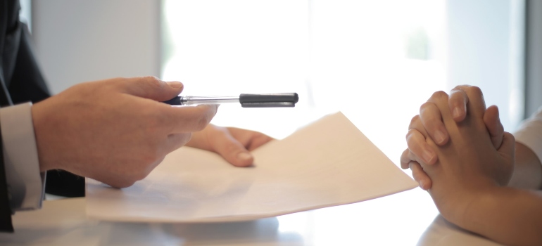 unrecognizable person signing a contract