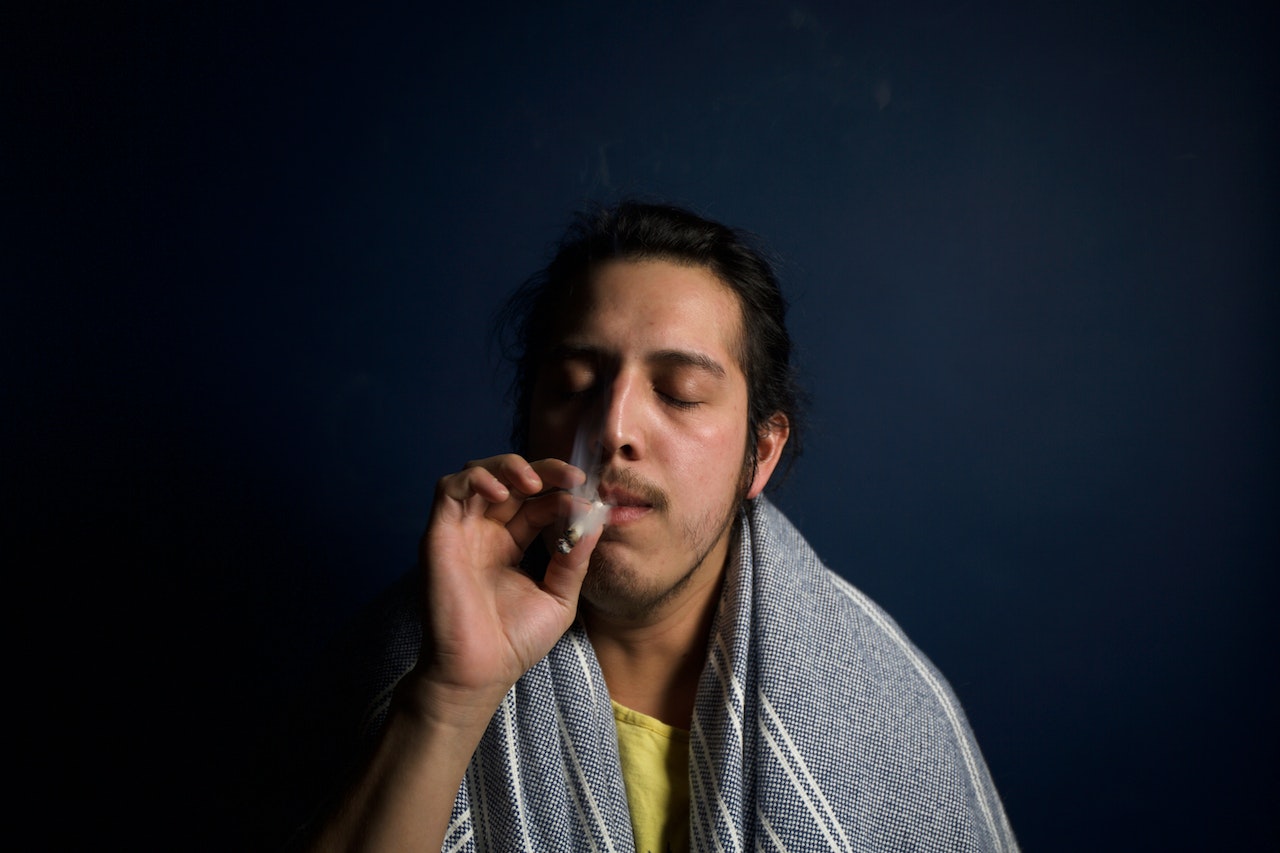 a man smoking marijuana, representing long-term side effects of marijuana abuse