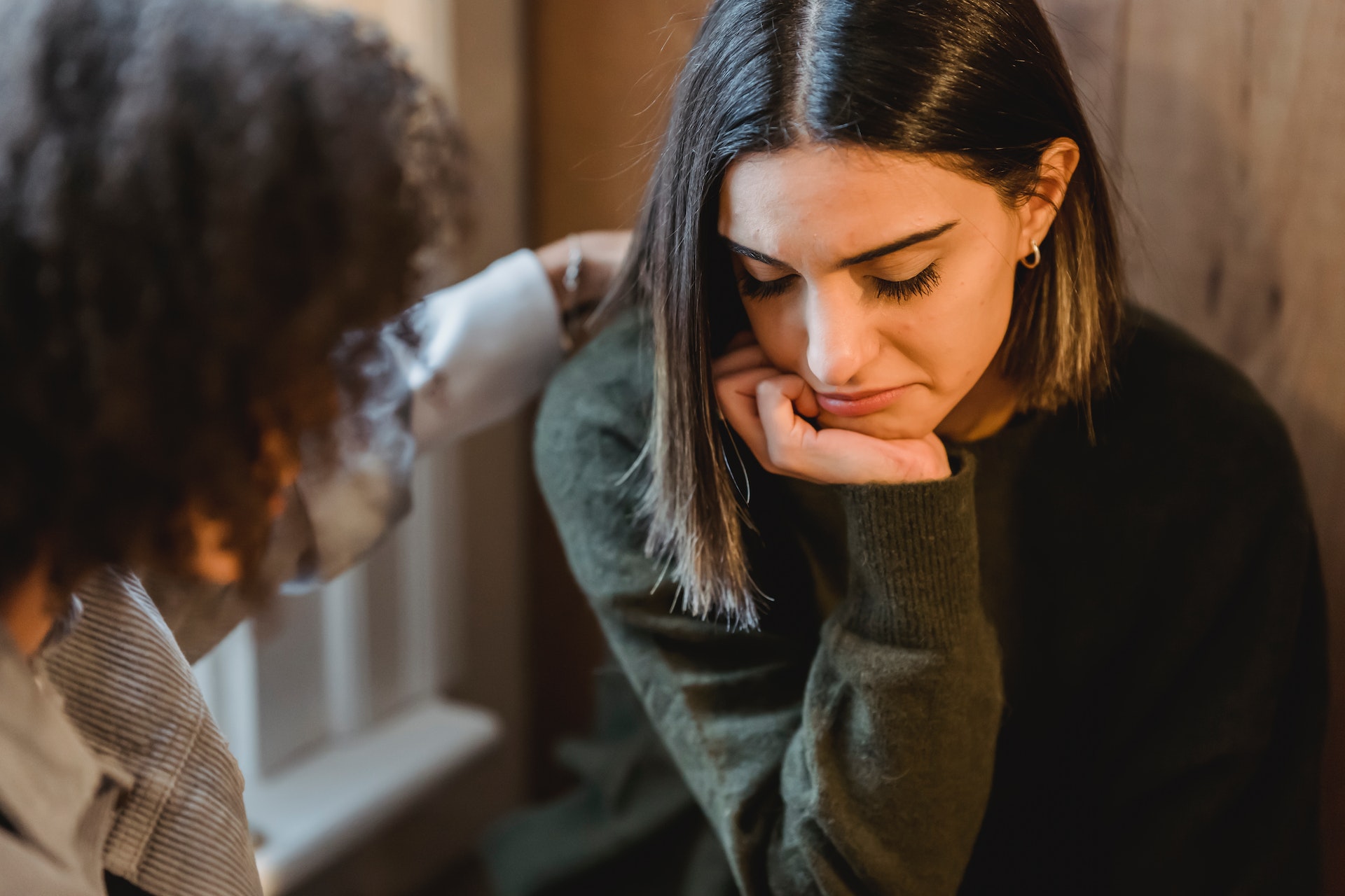 woman comforting her friend, representing challenges for women in recovery