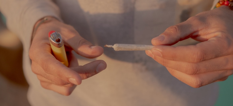 a man making a joint not knowing the long-term side effects of marijuana abuse