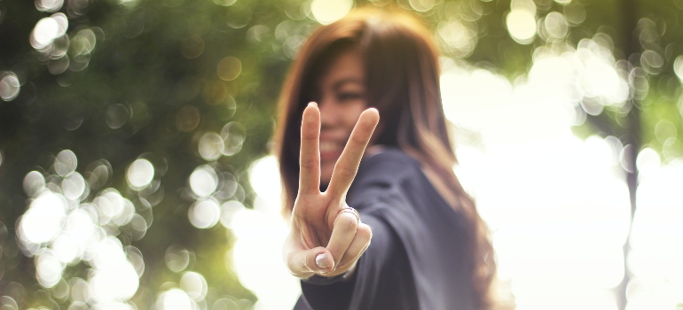 person showing a "peace" sign