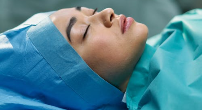 An unconscious woman on an operating table.