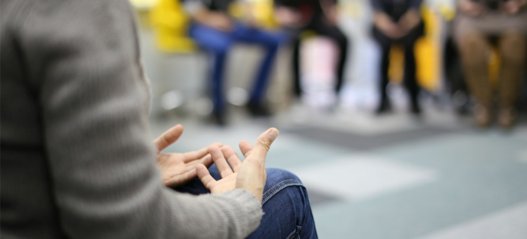 A close-up of a person speaking during a group therapy session.
