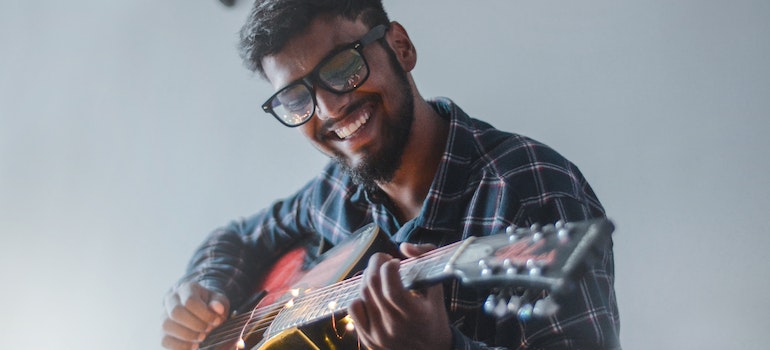 a man playing guitar and smiling