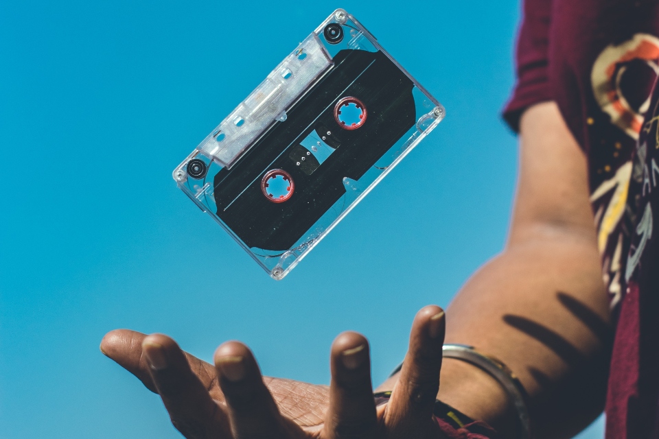 person catching an old music casette