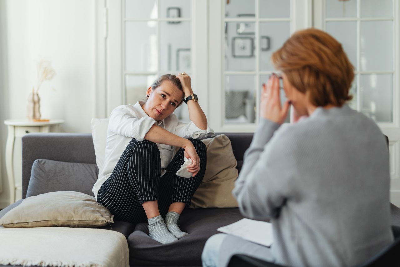 Worried woman receiving guidance from a counselor during a support session.