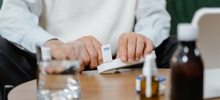 a person taking medicine from a dosage box