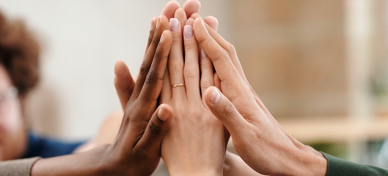 People touching hands in support.