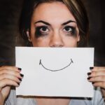 Woman holding fake smile to signal she has depression.