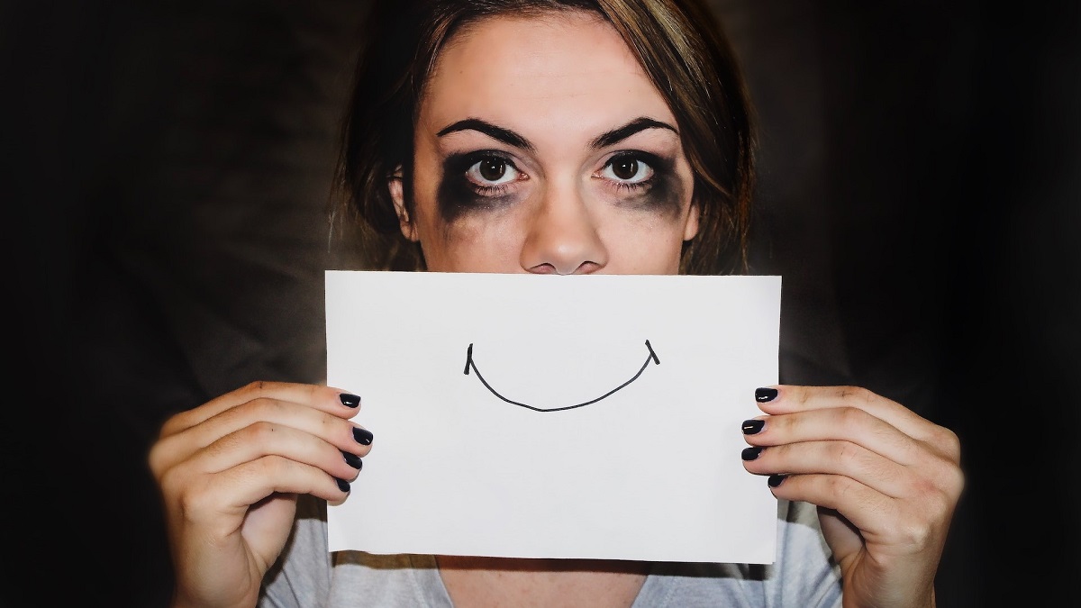 Woman holding fake smile to signal she has depression.