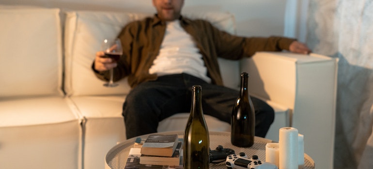 man sitting on a couch and drinking while considering Myths in Recovery