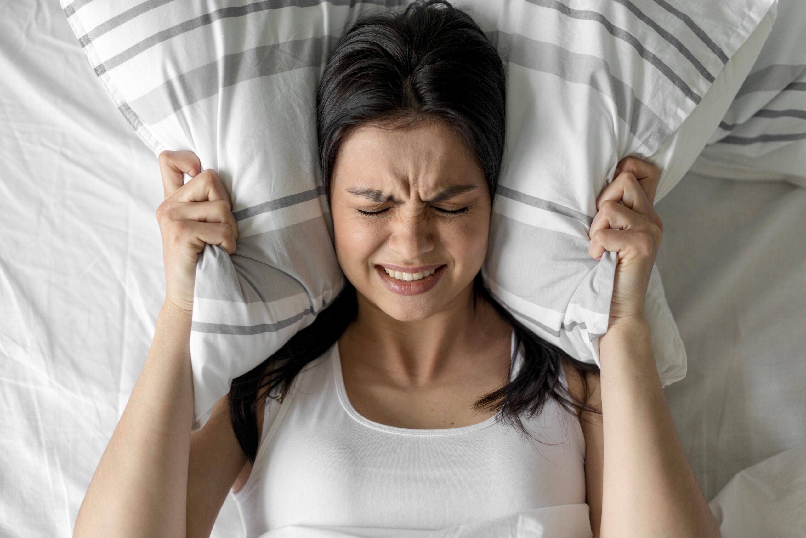 Young woman in frustration holding pillow during an epizode of Hangziety