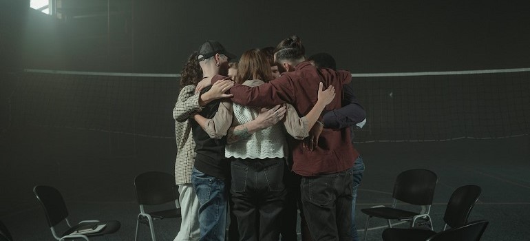 People hugging during group therapy session.