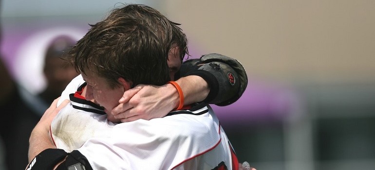 Men hugging during sports game.
