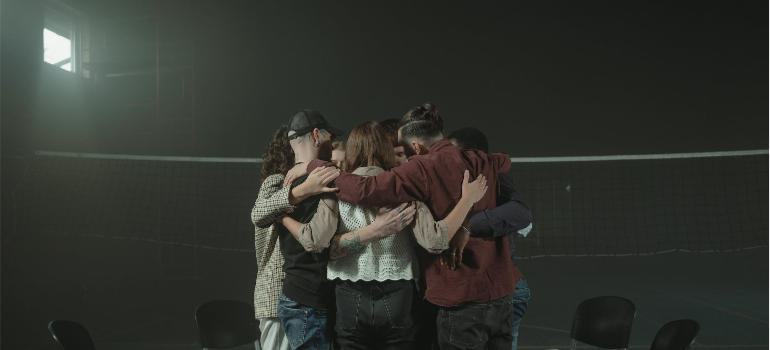 A group of people hugging after a group therapy session.