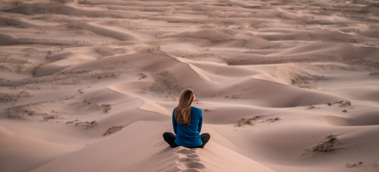 A woman meditating in the desert after being one year sober.