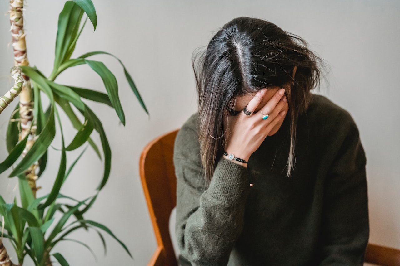 A woman feeling depressed while thinking about early-onset alcoholism in Pennsylvania's population.