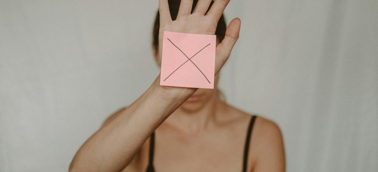 a woman holding a paper that says x