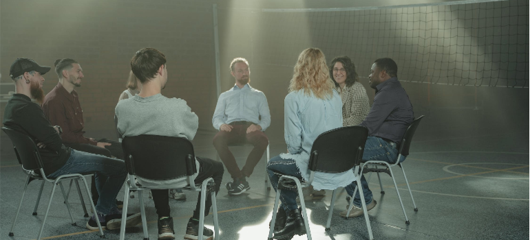 A group of people during a group therapy session indoors.