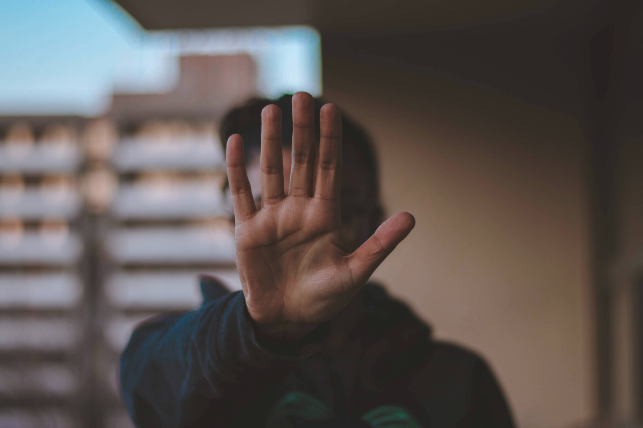 a person holding their hand as a way to set boundaries to with a loved one in recovery