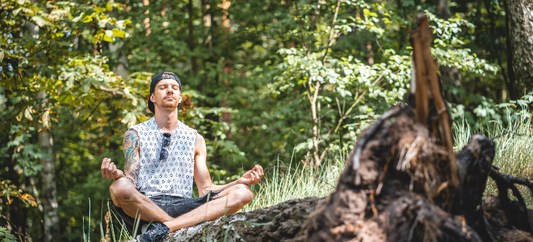 a men in the woods meditating after reading the article" The Role of Partners in Men's Recovery Journey"