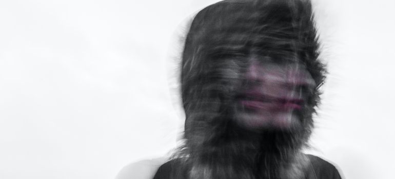 a blurred face of a woman with a hoody 